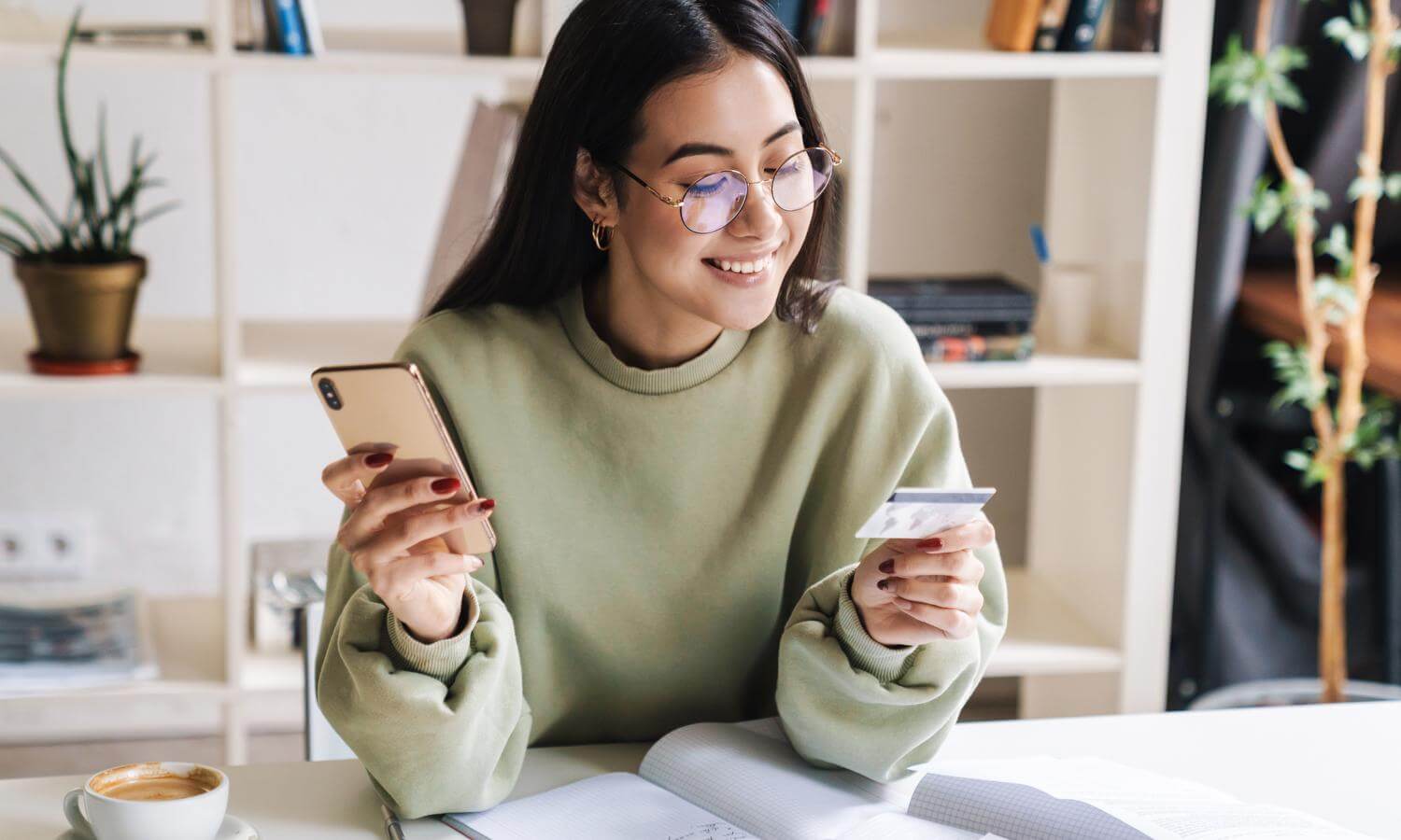 Woman smiling, looking at credit card in her hand